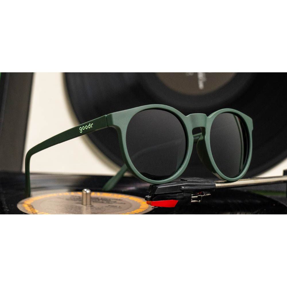 Óculos de sol verde oliva unissex com armação redonda e lente verde oliva degradê não refletiva, polarizada com proteção UV400. O acessório é leve, confortável e não escorrega ou pula no rosto ao realizar esportes.