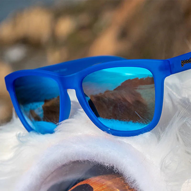 Óculos de sol azul unissex com armação quadrada e lente azul espelhada, polarizada com proteção UV400. O acessório é leve, confortável e não escorrega ou pula no rosto ao realizar esportes.