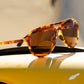 Óculos de sol Goodr Brasil modelo aviador com armação em estampa tartaruga e lentes marrons polarizadas.