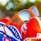 Óculos de sol Goodr Brasil Donkey Goggles com armação laranja fosca e lentes azuis espelhadas polarizadas.