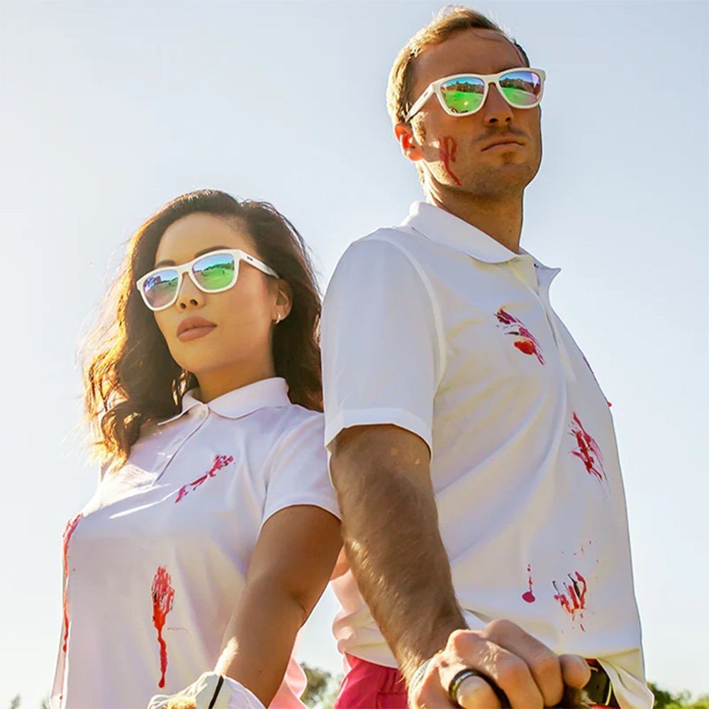 Homem e mulher usando óculos de sol Goodr Brasil Au Revoir, Gopher com armação branca e lentes espelhadas ao ar livre.