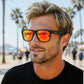 Homem usando óculos de sol Goodr Brasil BFG com armação preta e lentes espelhadas amarelas em um dia ensolarado.