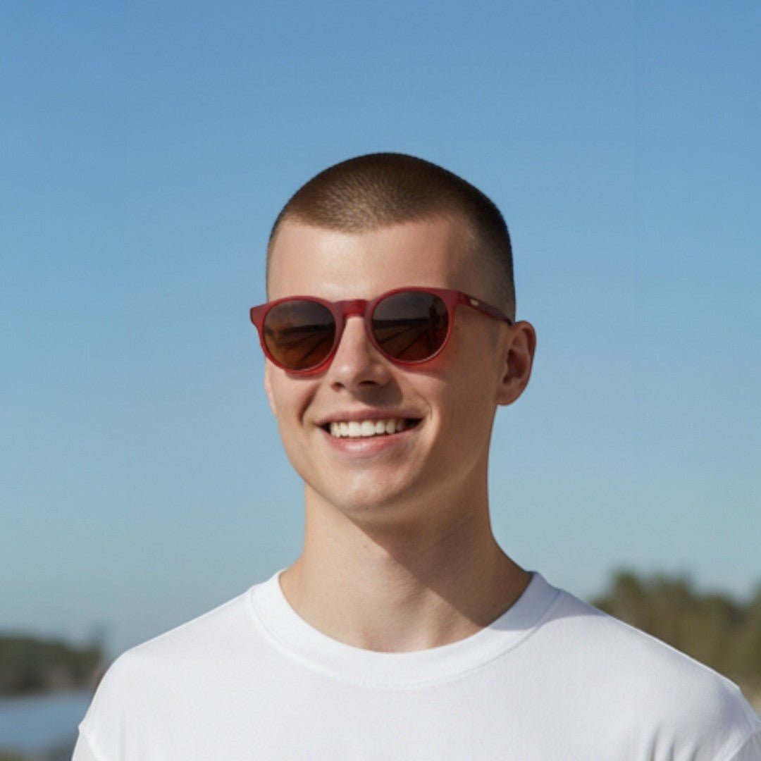 Homem usando óculos de sol Goodr Brasil modelo Circle G com armação bordô e lentes marrons polarizadas ao ar livre