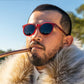 Homem usando óculos de sol Goodr Brasil modelo Circle G com armação bordô e lentes polarizadas escuras.