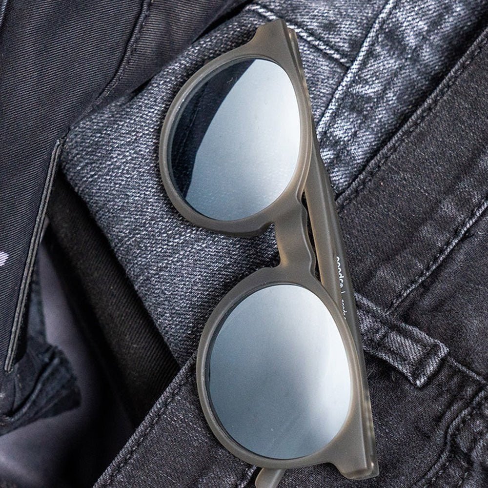 Óculos de sol Goodr Brasil modelo Circle G cinza com lentes espelhadas sobre tecido jeans escuro
