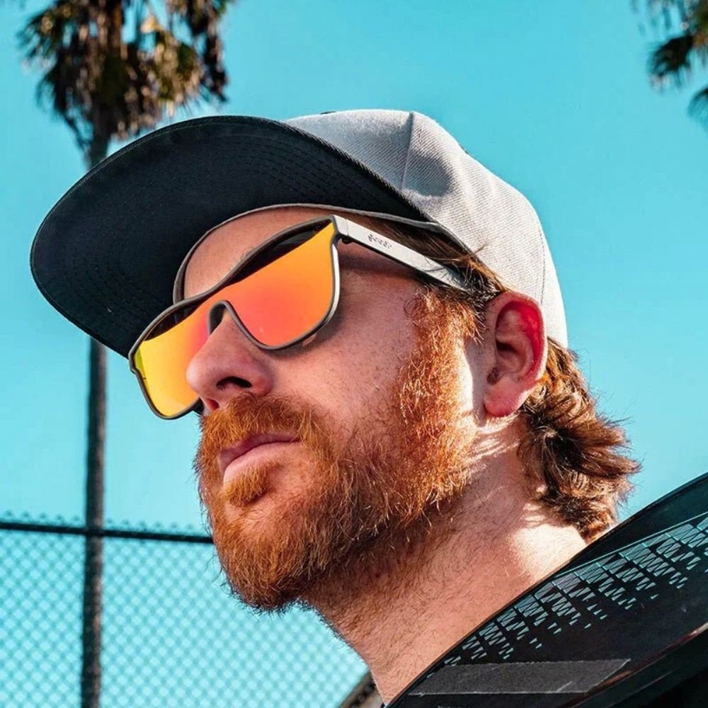 Homem ruivo usando óculos de sol Goodr Brasil Voight-Kampff Vision com armação cinza e lente laranja espelhada polarizada
