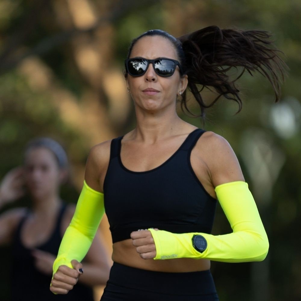 Mulher correndo ao ar livre usando óculos de sol Goodr Brasil modelo OG com armação e lentes pretas polarizadas.