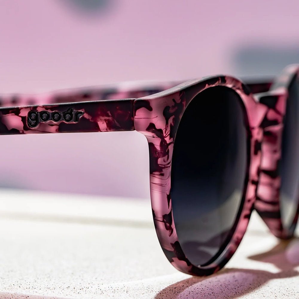 Óculos de sol Goodr Brasil modelo Circle G com armação redonda rosa estampada e lentes pretas polarizadas.