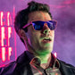 Homem usando óculos de sol Goodr Brasil VRG com armação rosa e lentes roxas espelhadas em ambiente festivo com luz neon
