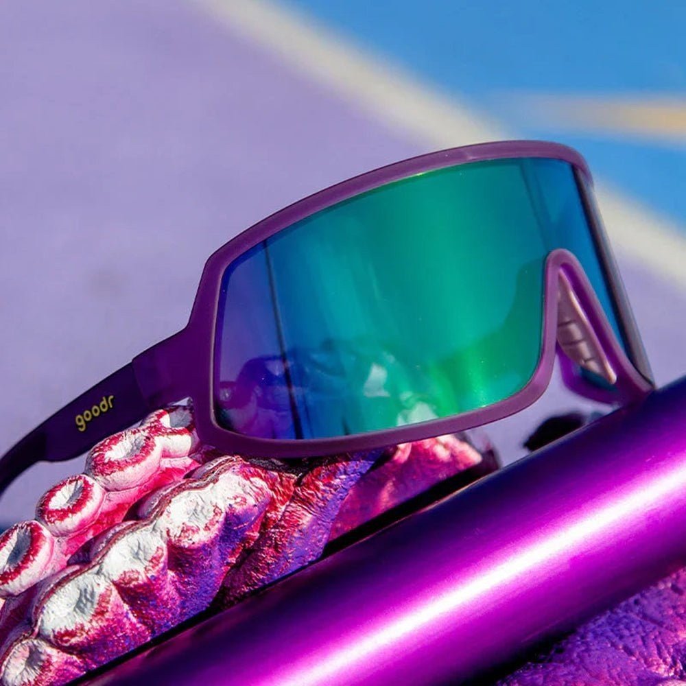 Óculos de sol Goodr Brasil roxo com lente única espelhada verde, design esportivo estilo wrap para corrida e ciclismo.