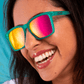 Mulher utilizando os oculos verde com lente rosa espelhada de armação quadrada pequena.