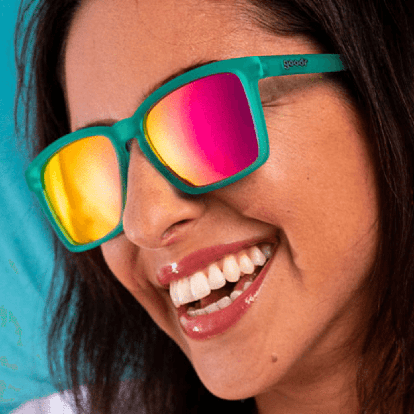 Mulher utilizando os oculos verde com lente rosa espelhada de armação quadrada pequena.