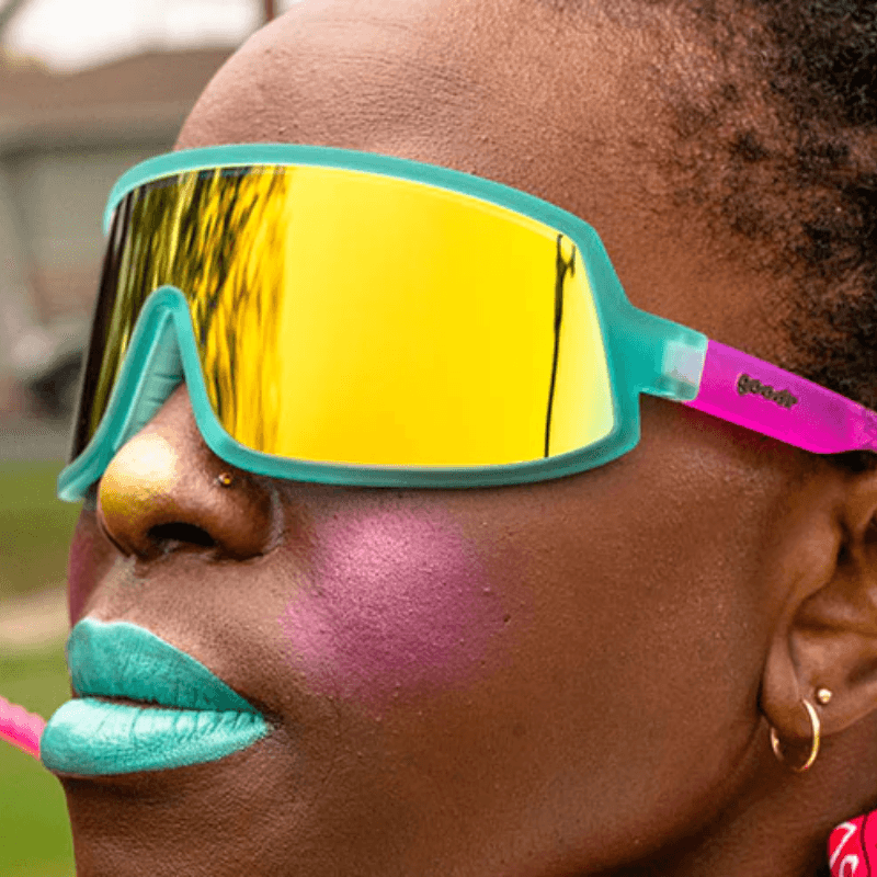 Óculos de sol verde-rosa degradê unissex com armação máscara e lente única amarela espelhada, polarizada com proteção UV400. O acessório é leve, confortável e não escorrega ou pula no rosto ao realizar esportes.