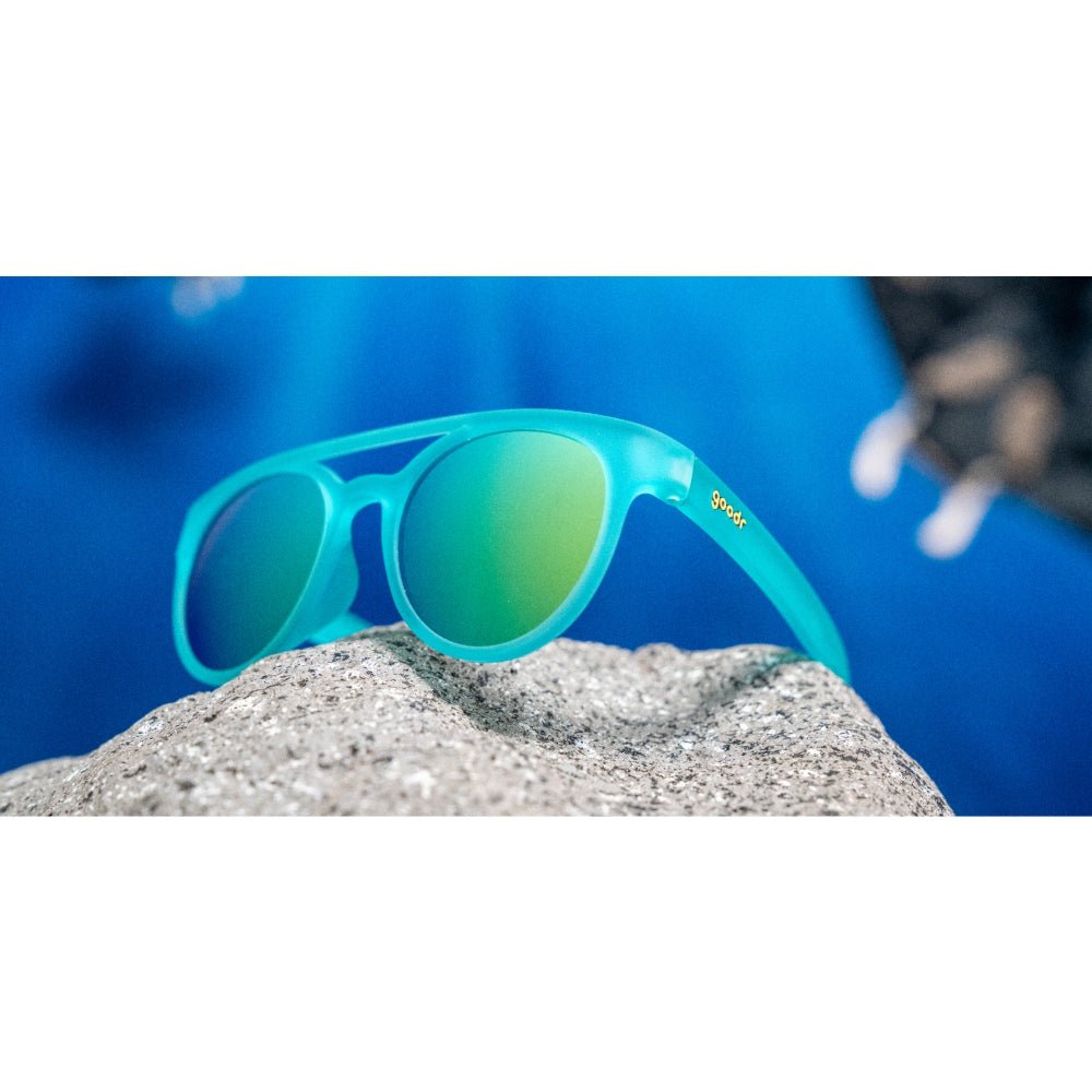 Óculos de sol azul unissex com armação redonda e lente azul espelhada, polarizada com proteção UV400. O acessório é leve, confortável e não escorrega ou pula no rosto ao realizar esportes.
