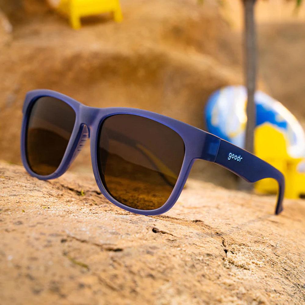 Óculos de sol azul marinho unissex com armação quadrada para rosto grande e lente marrom degradê não refletiva, polarizada com proteção UV400. O acessório é leve, confortável e não escorrega ou pula no rosto ao realizar esportes.