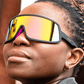 Óculos de sol preto unissex com armação máscara e lente única rosa espelhada, polarizada com proteção UV400. O acessório é leve, confortável e não escorrega ou pula no rosto ao realizar esportes.