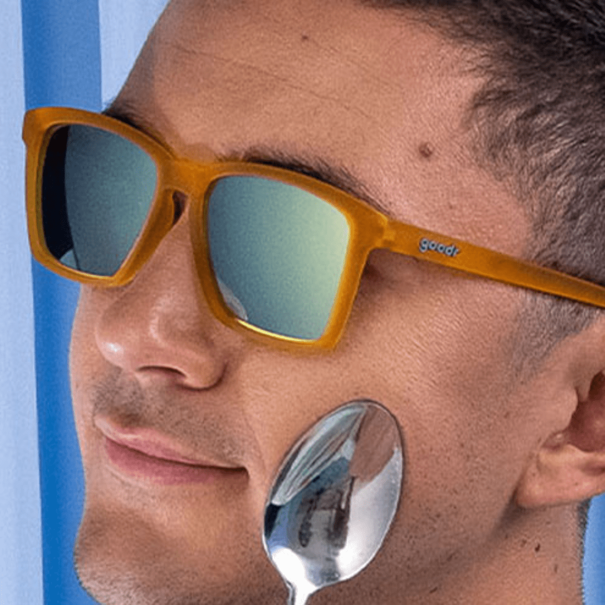 Óculos de sol laranja unissex com armação quadrada para rosto pequeno e lente azul espelhada, polarizada com proteção UV400. O acessório é leve, confortável e não escorrega ou pula no rosto ao realizar esportes.