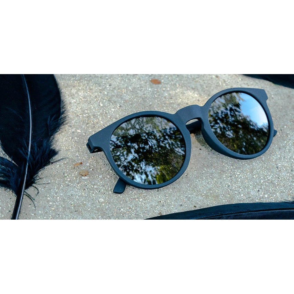Óculos de sol preto unissex com armação redonda e lente preta não refletiva, polarizada com proteção UV400. O acessório é leve, confortável e não escorrega ou pula no rosto ao realizar esportes.