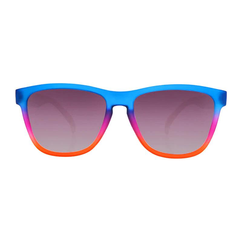 Óculos de sol azul-roxo degradê unissex com armação quadrada e lente lilás não espelhada, polarizada com proteção UV400. O acessório é leve, confortável e não escorrega ou pula no rosto ao realizar esportes.