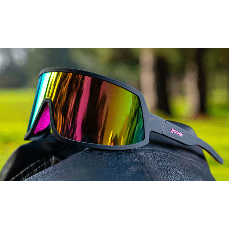 Óculos de sol preto unissex com armação máscara e lente única rosa espelhada, polarizada com proteção UV400. O acessório é leve, confortável e não escorrega ou pula no rosto ao realizar esportes.